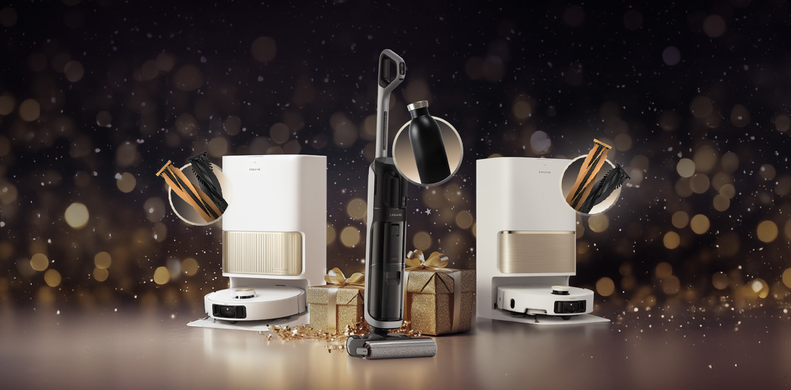 Biały robot sprzątający z bazą dokującą stoi na podświetlonym podeście, obok choinki z bombkami i prezentami w świątecznej scenografii z czerwono-złotymi dekoracjami